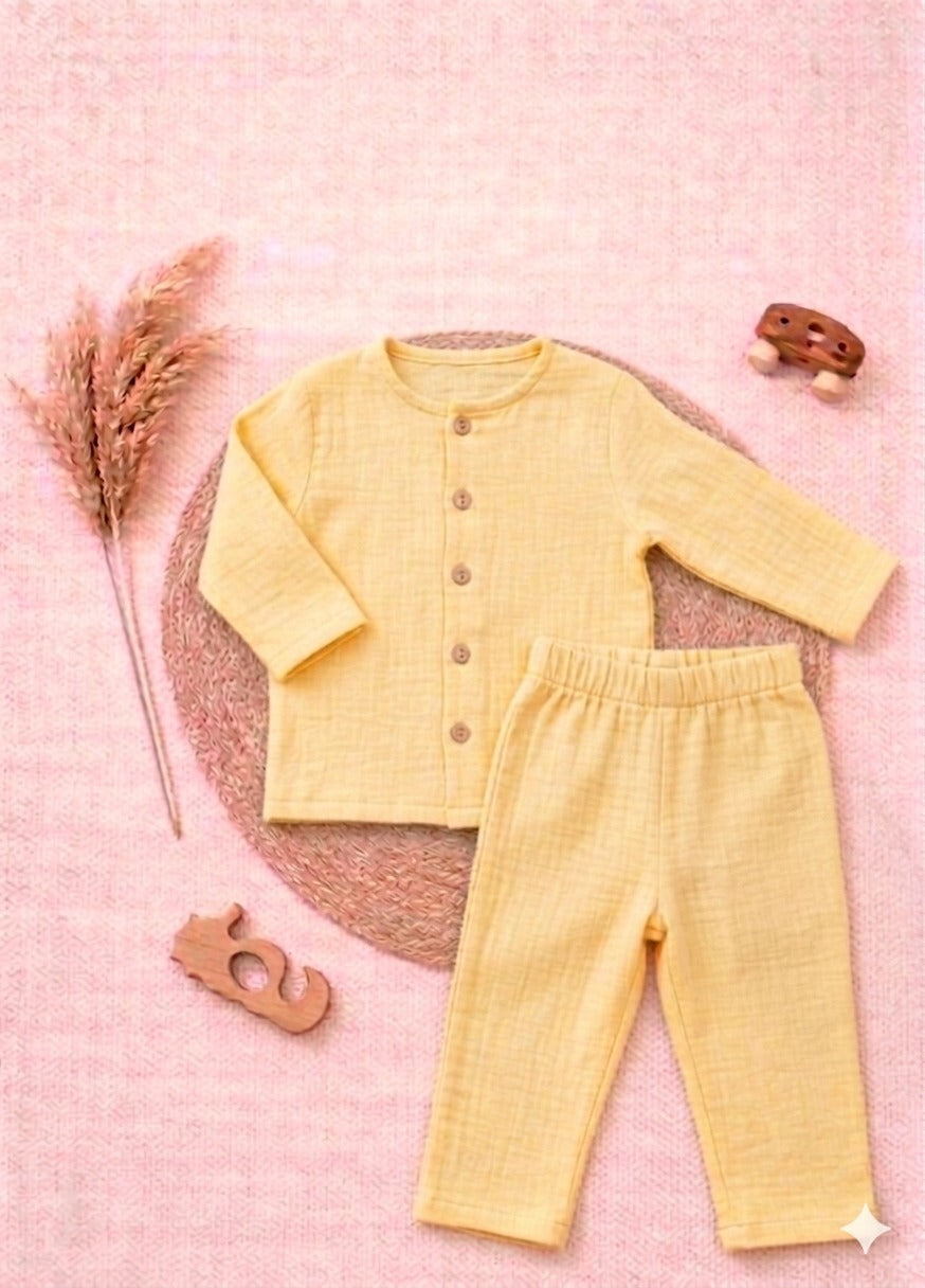 Yellow baby outfit with shirt and pants on a pink textured background